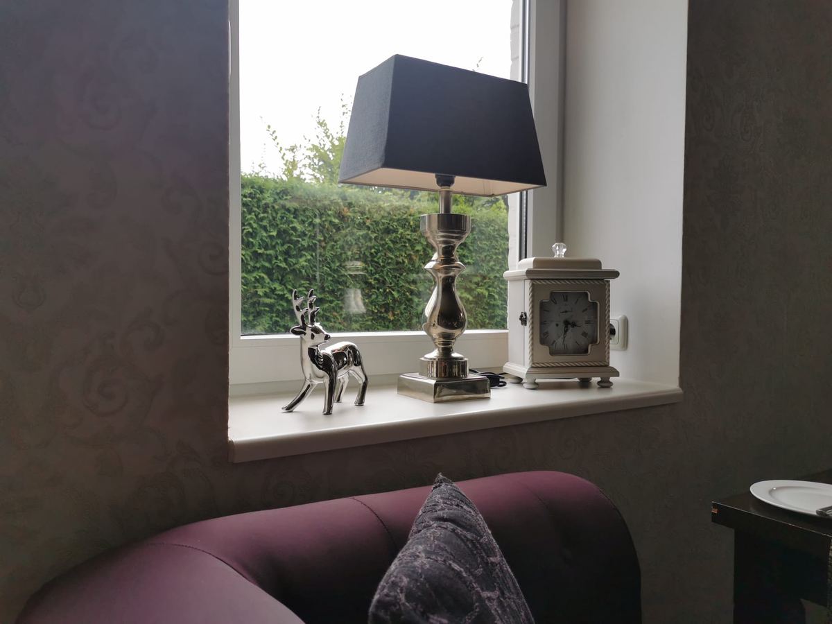 Sitzecke mit Polsterbank am Fenster, Tischlampe und Dekoration